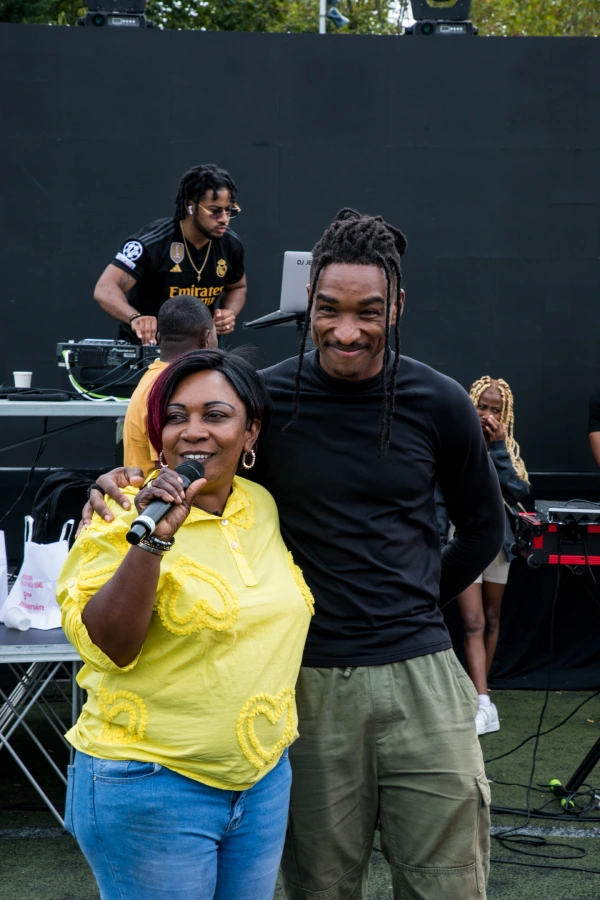 Femme en jaune avec micro et homme souriant.