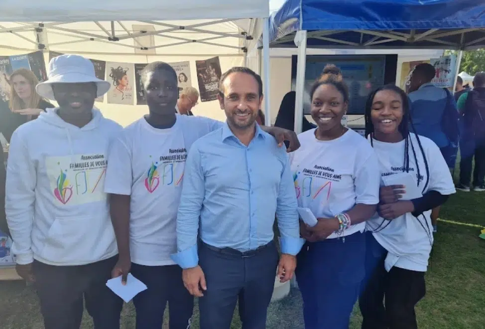 Groupe de personnes souriantes sous un stand